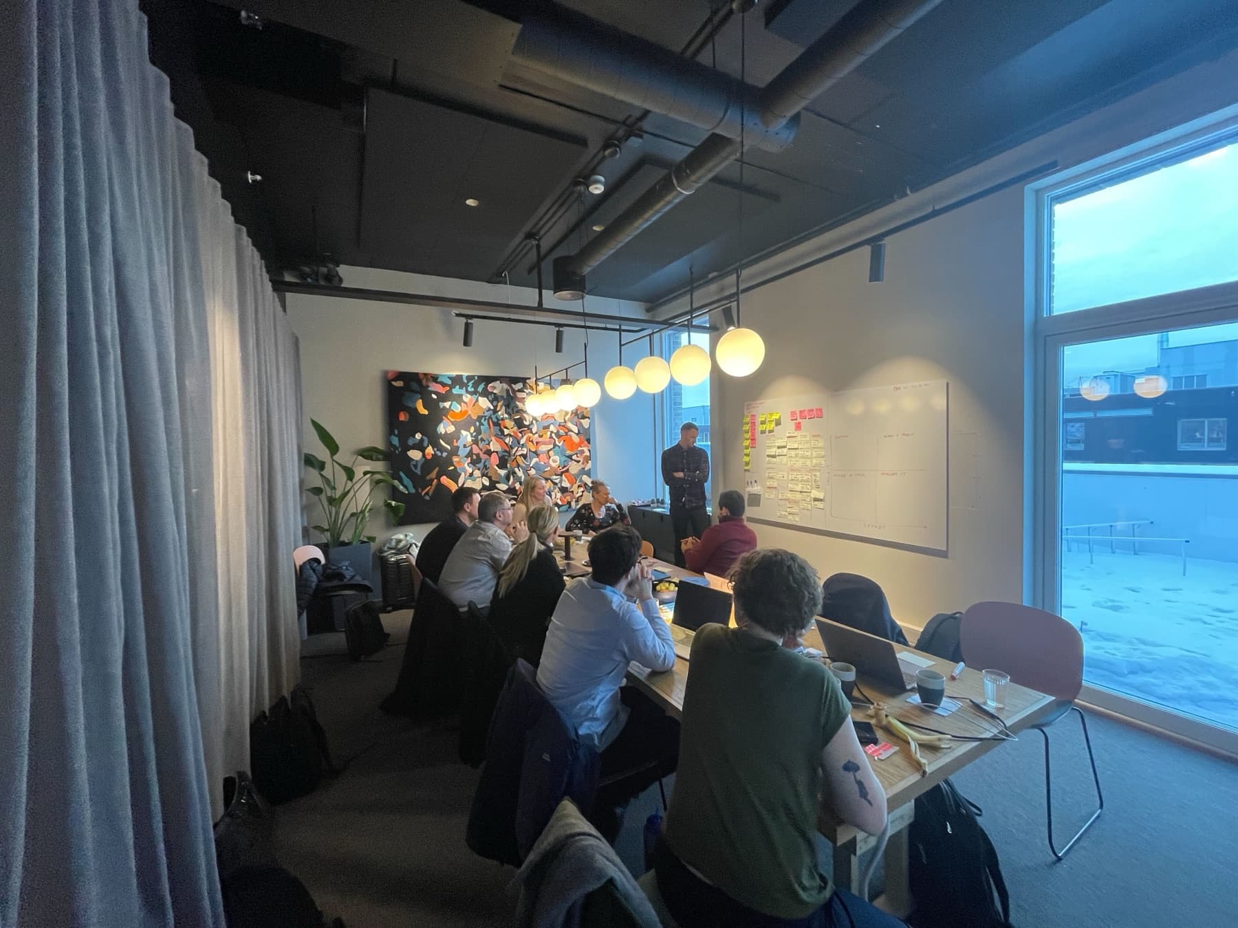 Deltakere foran tavla med post-its under en Lightning Decision Jam